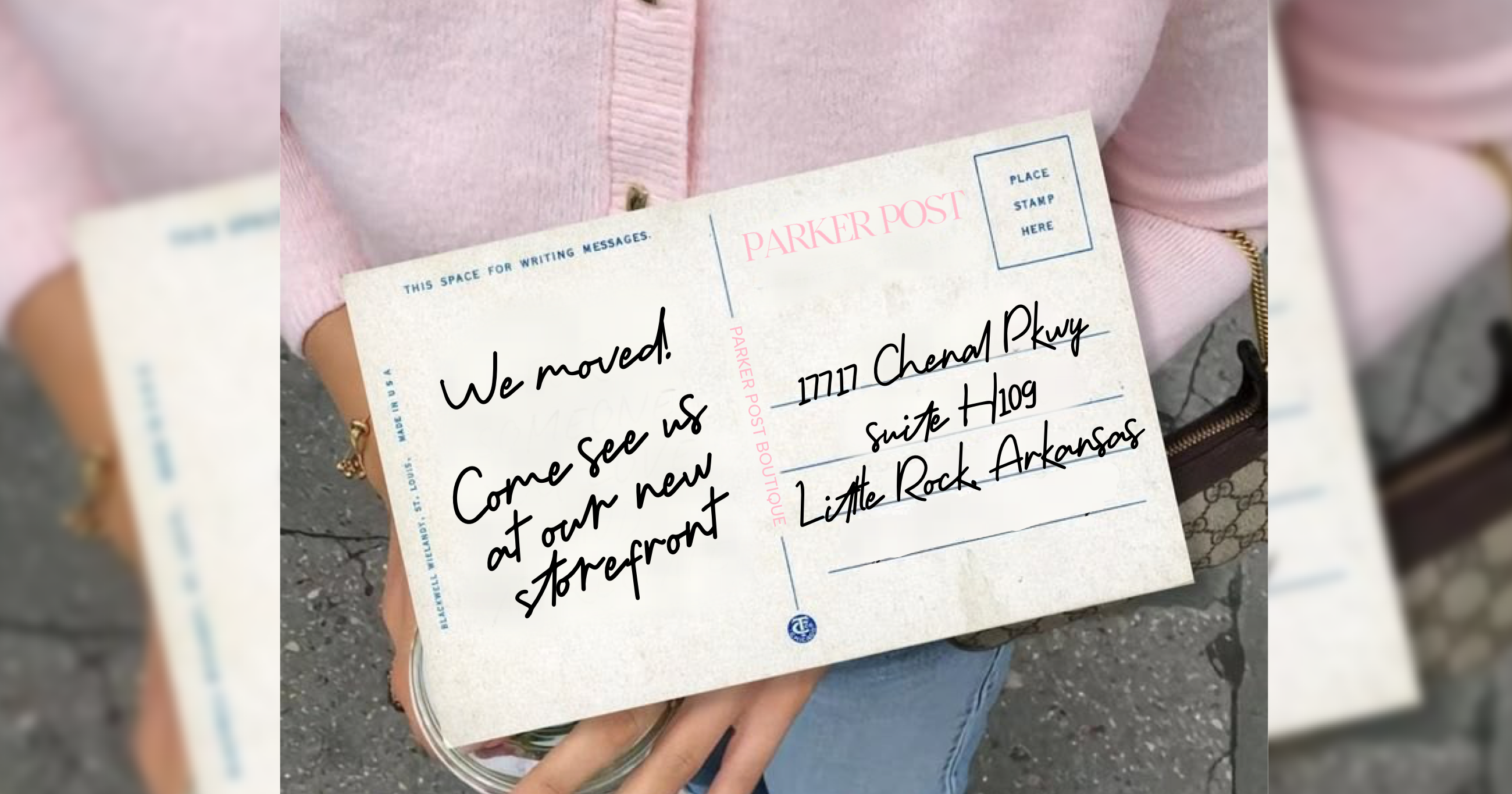 Handwritten postcard being held by a person with a pink shirt.